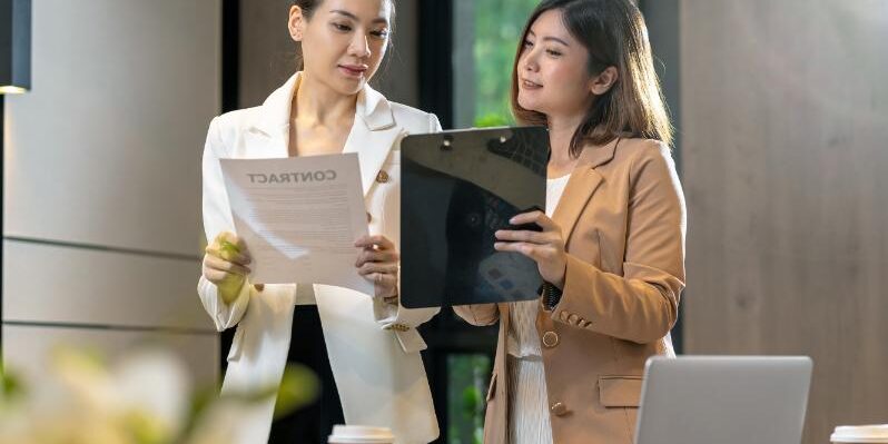 two-asian-businesswomen-discussing-with-the-partne-W9AU8XG